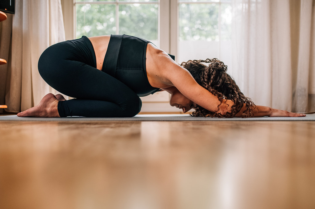 Woman stretching in extended puppy pose on yoga mat